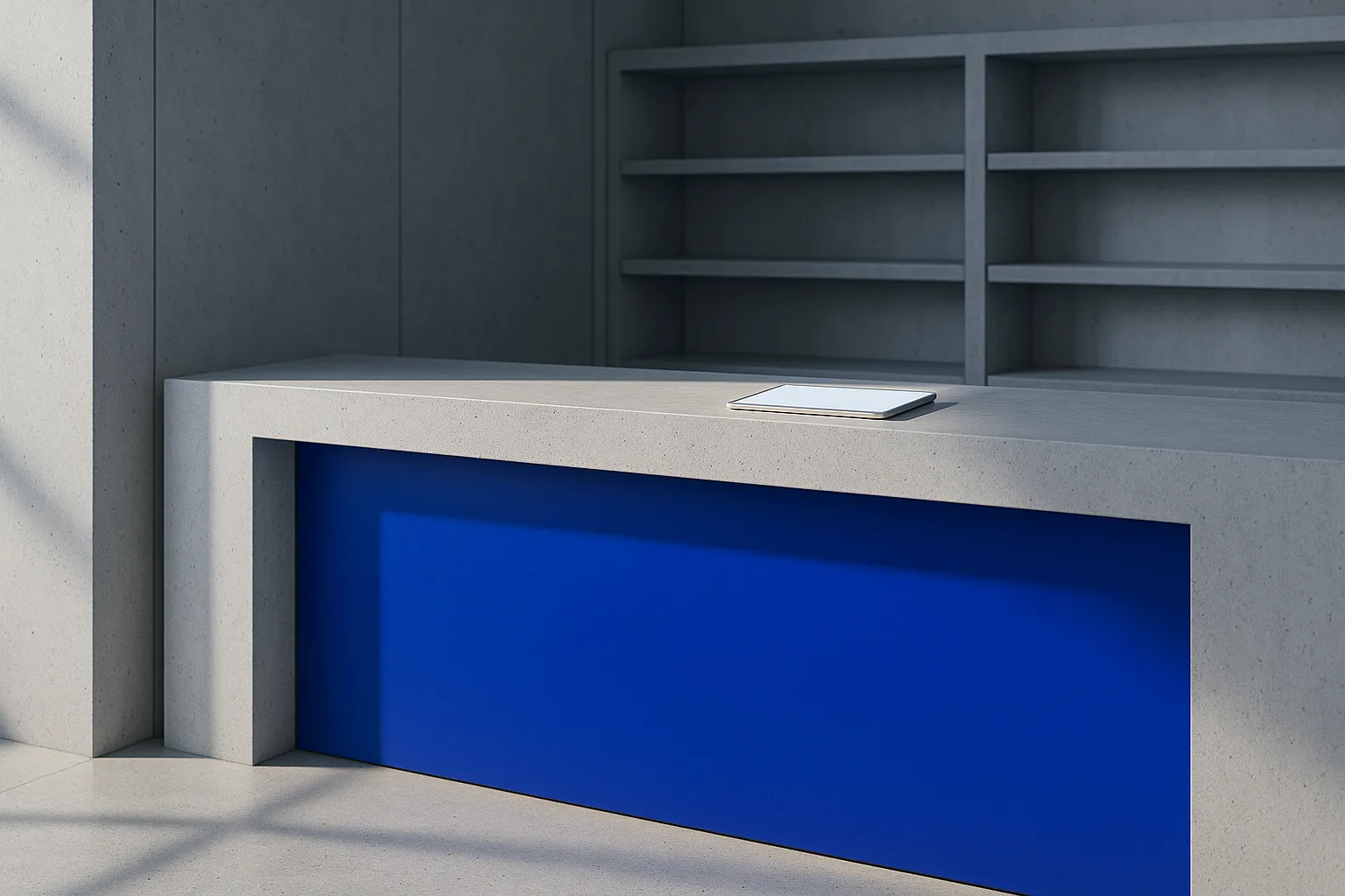 Pale concrete trade counter with a cobalt front panel and a blank tablet lying on the top